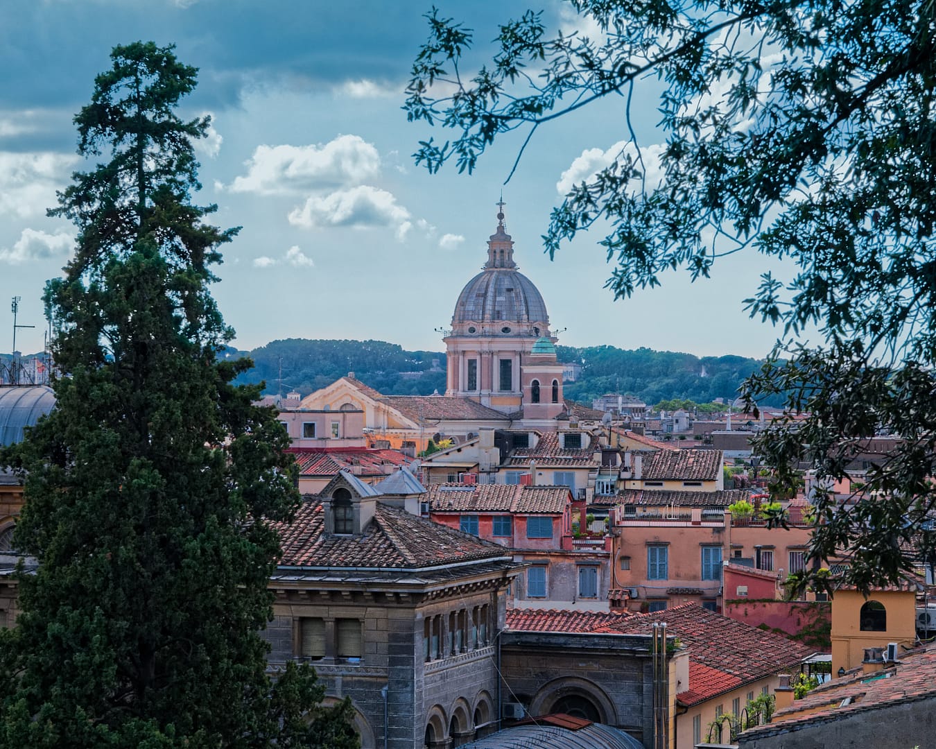 Vue sur les toits de Rome encadrée par de la végétation