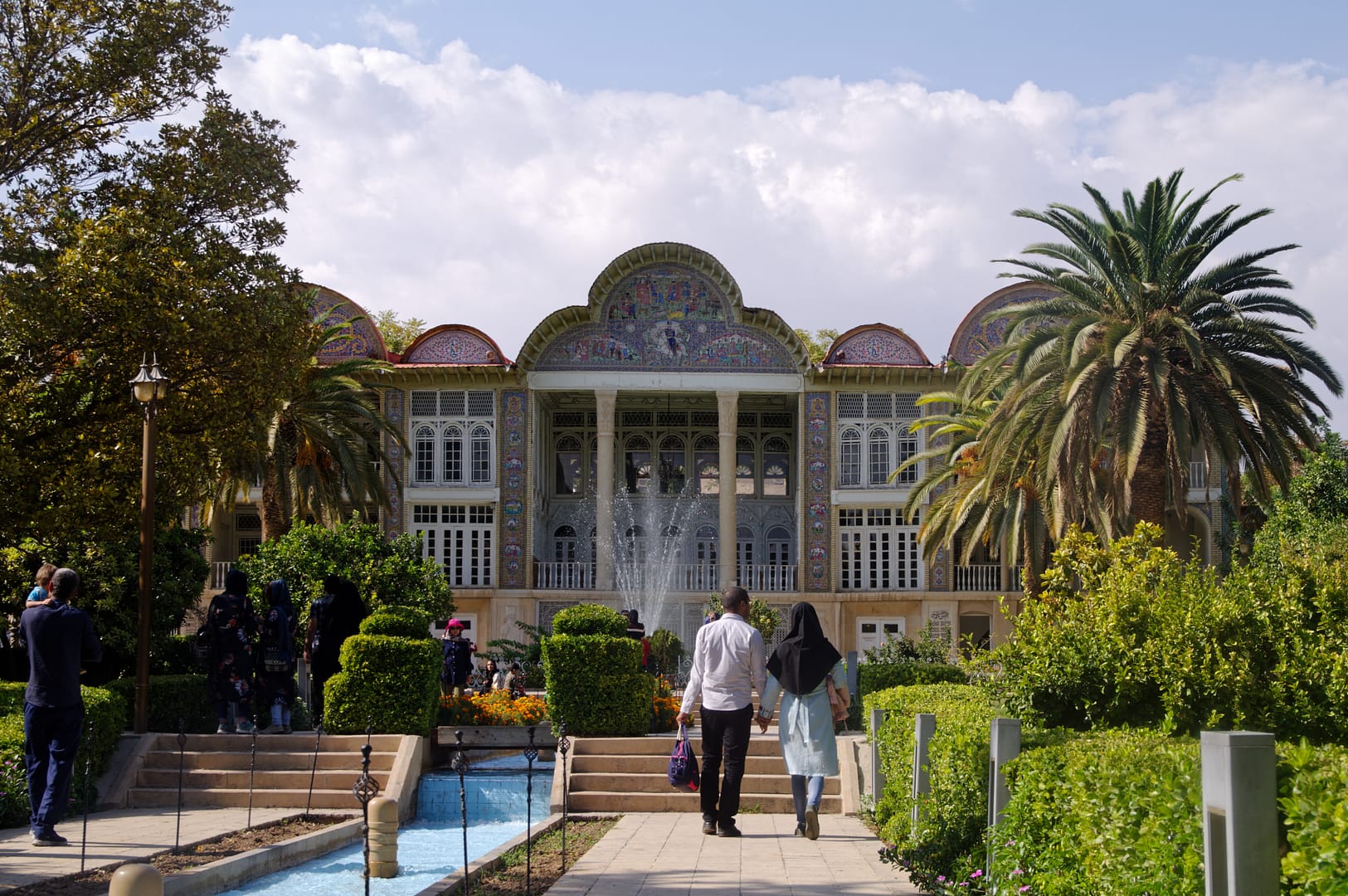 couple d'iranien se tiennent la main en remontant le jardin Eram de Chiraz