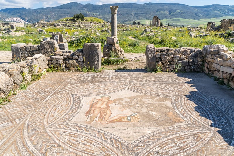 Mosaïque et colonne romaines avec la montagne en arrière plan